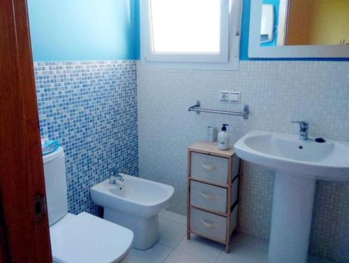 ein Badezimmer mit einer weißen Toilette und einem Waschbecken in der Unterkunft Barraña Boiro Mar in Boiro