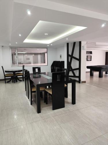 a dining room with a black table and chairs at Penthouse lujo, Parque La Carolina, Piscina, parqueo 3 habitaciones in Quito