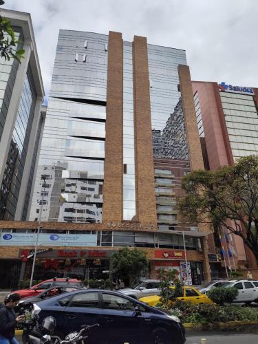 a large building with cars parked in front of it at Penthouse lujo, Parque La Carolina, Piscina, parqueo 3 habitaciones in Quito