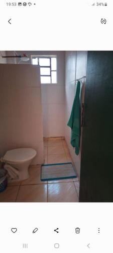 a bathroom with a toilet and a green towel at Pousada Paraíso Pedacinho Do Céu 2 in Águas de Lindóia