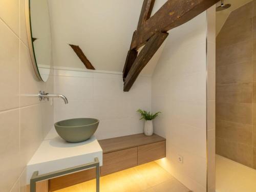 a bathroom with a bowl sink on a counter at Farmhouse in Zeeland with Windmill Views in Heinkensand