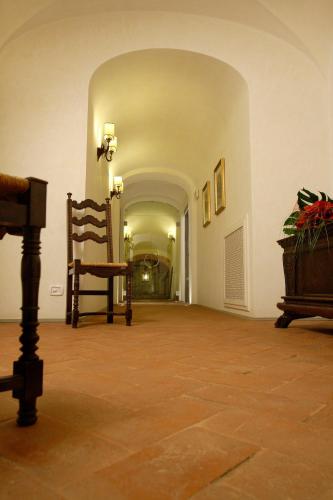 an empty hallway with a chair and a table at Villa Barberino in Meleto