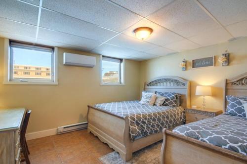 a bedroom with two beds and two windows at Red Rock Rentals in Cannonville