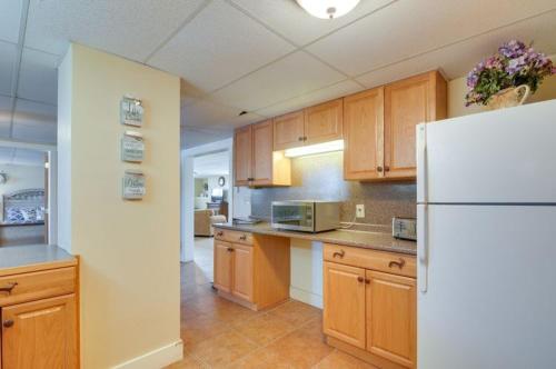 a kitchen with wooden cabinets and a white refrigerator at Red Rock Rentals in Cannonville