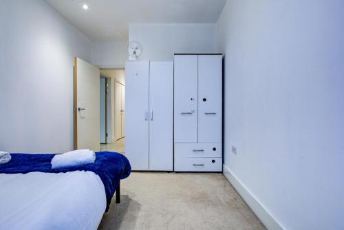 a white bedroom with a bed and a closet at 1 BR Flat 6 Mins From Heathrow Airport Flat 25 in Harmondsworth