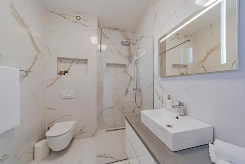 a white bathroom with a sink and a toilet at Penthouse apartment Optimum in Korčula