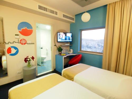 um quarto de hotel com duas camas e uma televisão em Grand Park Hotel Jerusalem em Jerusalém