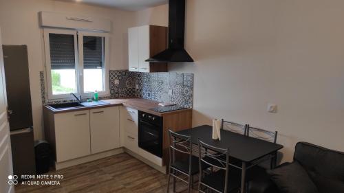 - une cuisine avec une table, une cuisinière et un évier dans l'établissement L'envol, à Athis-Mons