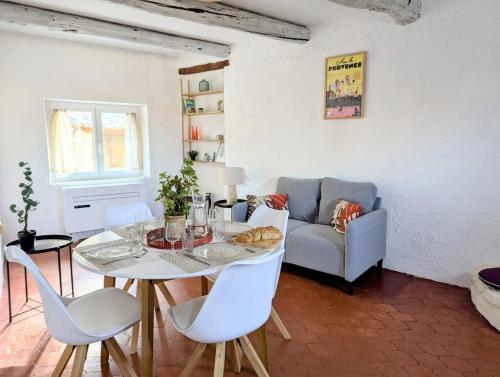 un salon avec une table, des chaises et un canapé dans l'établissement Le Joannis - Tranquillité en centre historique, à Malaucène