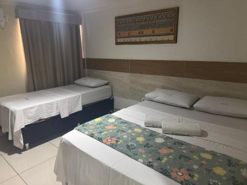 two beds in a small room with at Hotel Orla Guest House in Petrolina