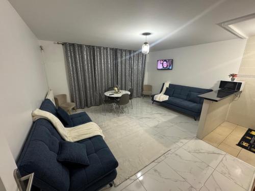 un salon avec des canapés bleus et une télévision dans l'établissement Quiet apartment near metro, à Pantin