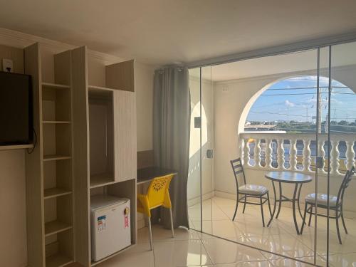 a room with a balcony with a table and chairs at Hotel Orla Guest House in Petrolina