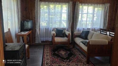 a living room with a couch and a tv at Cabaña el rincón in Puerto Montt