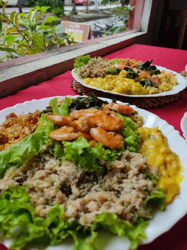 two plates of food on a red table at Hotel e Restaurante Casa Paraense Original, px ao aeroporto in Manaus