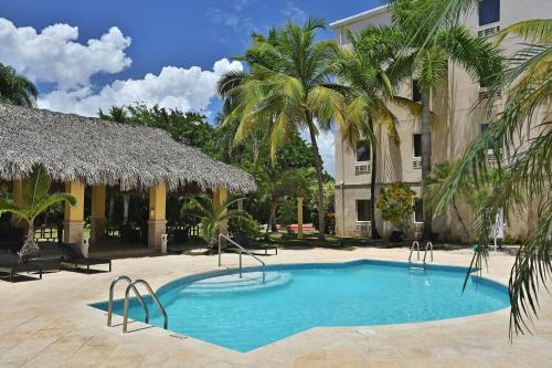 a swimming pool in front of a building with palm trees at Four Points by Sheraton Santo Domingo in Santo Domingo