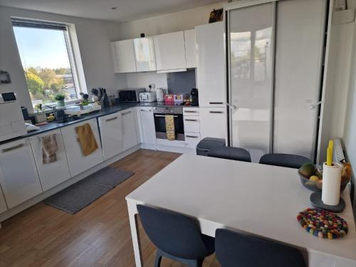 a kitchen with white cabinets and a table and chairs at Bright and Modern Forest Hill Flat - Flexible Stay in Forest Hill