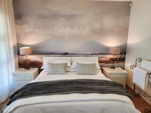 Un dormitorio con una gran cama blanca con dos lámparas. en At Let se Plek, en Jeffreys Bay