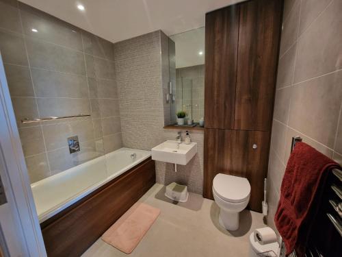 a bathroom with a toilet and a tub and a sink at Bright and Modern Forest Hill Flat - Flexible Stay in Forest Hill