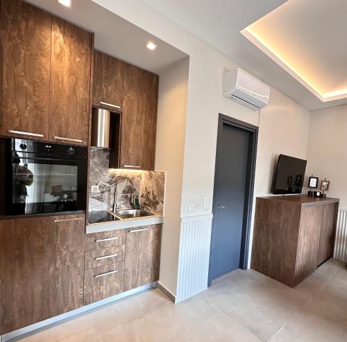 a kitchen with wooden cabinets and a sink at Central Luxury Apartment Maison De Luxx A10 in Larisa