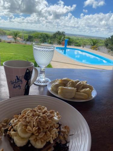 une table avec deux assiettes de nourriture et une boisson dans l'établissement Recanto do Sossego, à São José de Mipibu