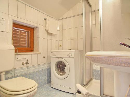 un bagno con lavatrice e lavandino di House Sunce a Orasac (Valdinoce)
