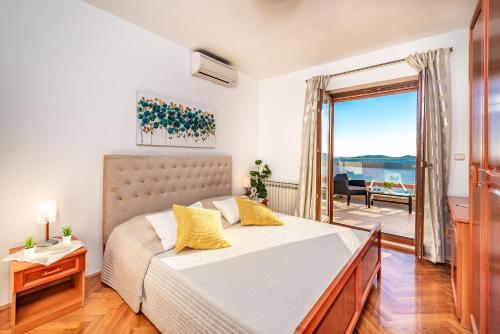 una camera da letto con un letto con vista sull'oceano di House Sunce a Orasac (Valdinoce)