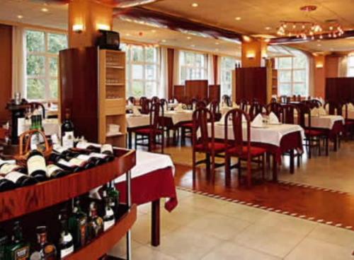 a restaurant with tables and chairs and bottles of wine at Cityexpress Hotel Ciprés in Bayón