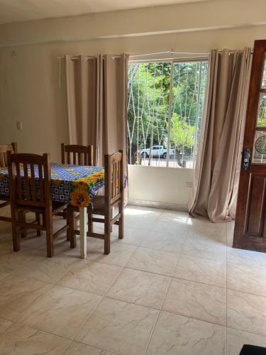 una sala da pranzo con tavolo, sedie e una finestra di Mango Home Iguazú a Puerto Iguazú