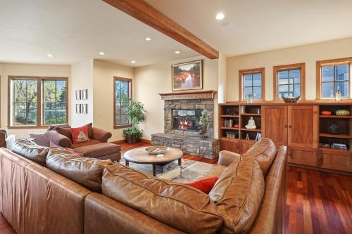 a living room with a leather couch and a fireplace at Drake Park Villa in Bend