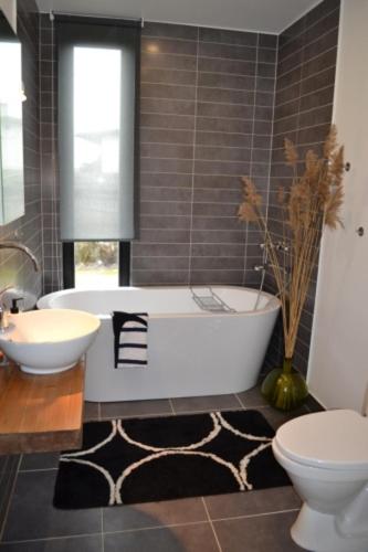 a bathroom with a tub and a toilet and a sink at Härmati puhkemaja- Riverside Holiday Home in Nasva