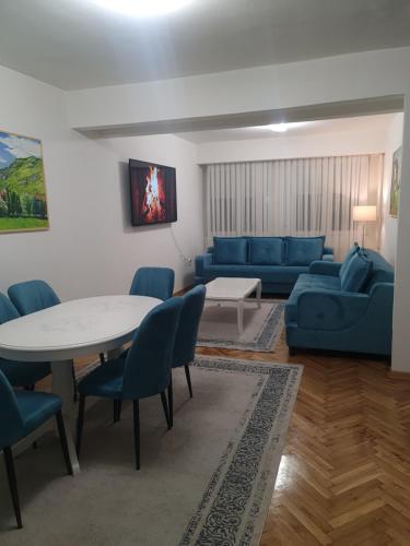 a living room with a blue couch and a table and chairs at Turquoise Apartment in Novi Pazar