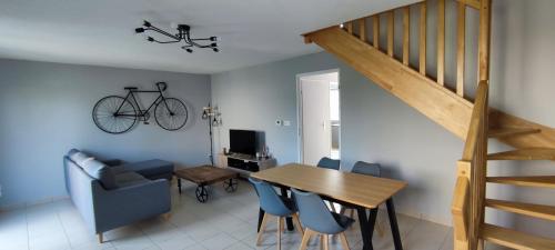 - un salon avec une table et un vélo sur le mur dans l'établissement Chez Irène & Alan - Maison Pila, à La Fresnais