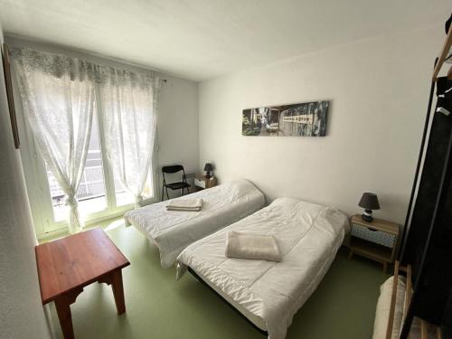 une chambre avec deux lits, une table et une fenêtre dans l'établissement Résidence Domaine Des Sables - 054 - Maison en duplex dans une résidence 3 étoiles MAE-2361, à Soulac-sur-Mer