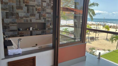 a bathroom with a window and a view of the beach at Club do Balanço Pousada e Restaurante in Morro de São Paulo