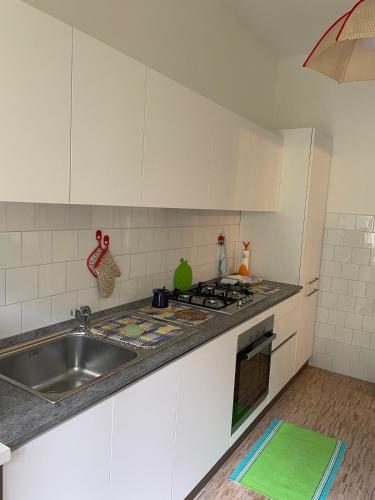 a kitchen with white cabinets and a sink at Appartamento Ragozza in Pieve Vergonte in Pieve Vergonte