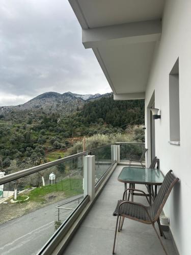 a balcony with a table and chairs and a view at Archontissa's House in mountainous village Drakona 22km from Chania in Dhrakóna