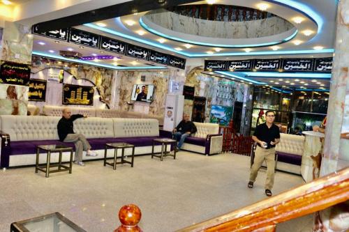 a man standing in the middle of a lobby at Hotel Janat Al Naim in Karbala