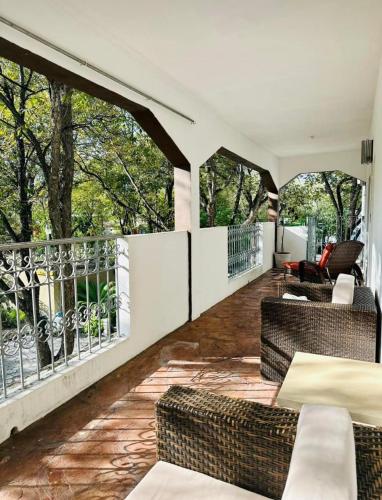 a patio with chairs and tables on a balcony at La Casita Inn Bustamante in Bustamante