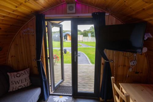 a view from the inside of a tiny house with a sliding door at Fulshaw Mill Holidays in Stewarton