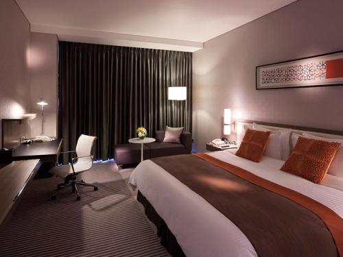 a hotel room with a large bed and a desk at Ramada Plaza by Wyndham Suwon in Suwon