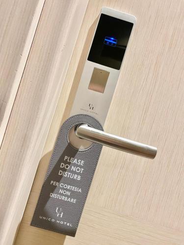 a remote control with a key on a door at Unico Hotel in Ossona