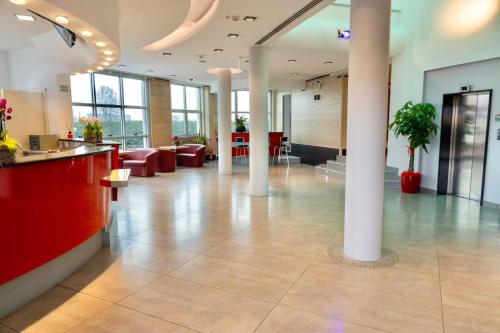 a lobby of a building with columns and a reception desk at Unico Hotel in Ossona