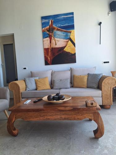 a living room with a couch and a wooden coffee table at Evgoro - Infinite View in Tsoútsouros