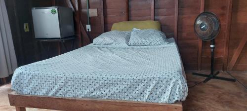 a bedroom with a bed with a fan next to it at Cabaña Punta Cocos in Holbox Island