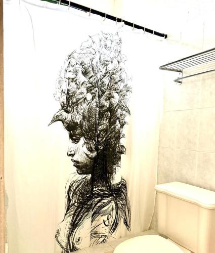 a drawing of a woman in a shower curtain in a bathroom at La Casita Inn Bustamante in Bustamante