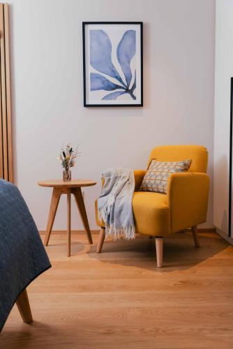 a living room with a yellow chair and a table at Hallstatt-Haus Elfriede in Hallstatt