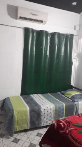 2 Betten in einem Zimmer mit grünem Vorhang in der Unterkunft Ultra in Ituzaingó