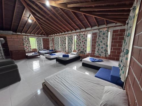 Una habitación con varias camas y sillas. en Finca Kikua, en San Rafael