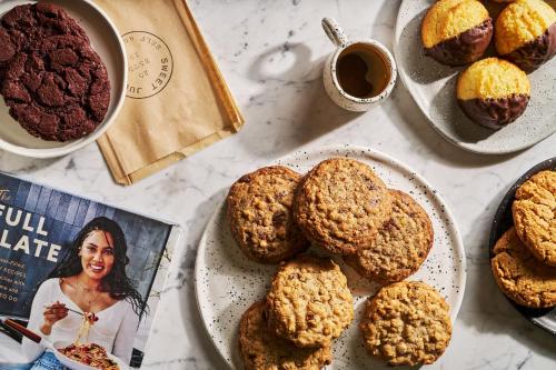 a table topped with plates of muffins and a magazine at Regent Santa Monica Beach in Los Angeles