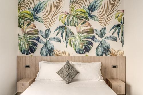 a bedroom with a bed with a tropical wallpaper at Royal Rooms B&B in Naples